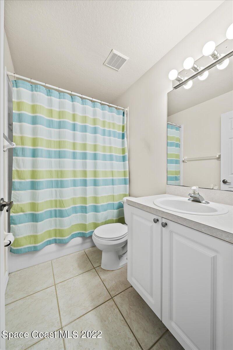 1965 Sundew Court Northeast Palm Bay, FL 32905 - Photo 14 of 29 a bathroom with a sink a toilet a shower and a mirror