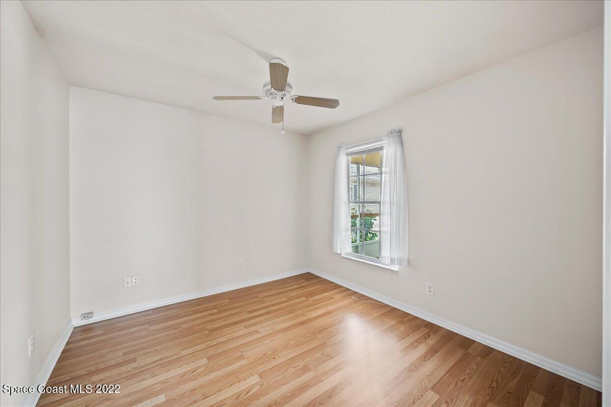 1965 Sundew Court Northeast Palm Bay, FL 32905 - Photo 15 of 29 an empty room with wooden floor ceiling fan and windows