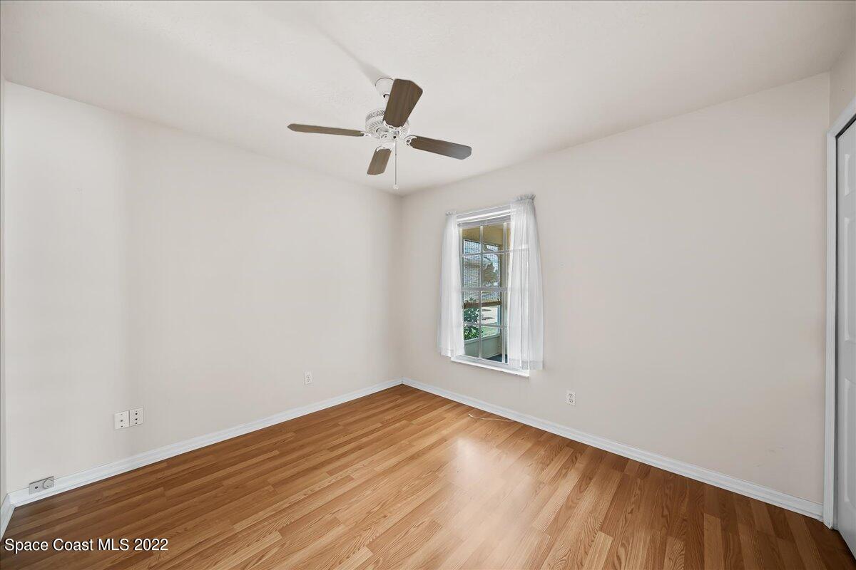1965 Sundew Court Northeast Palm Bay, FL 32905 - Photo 16 of 29 an empty room with wooden floor ceiling fan and windows