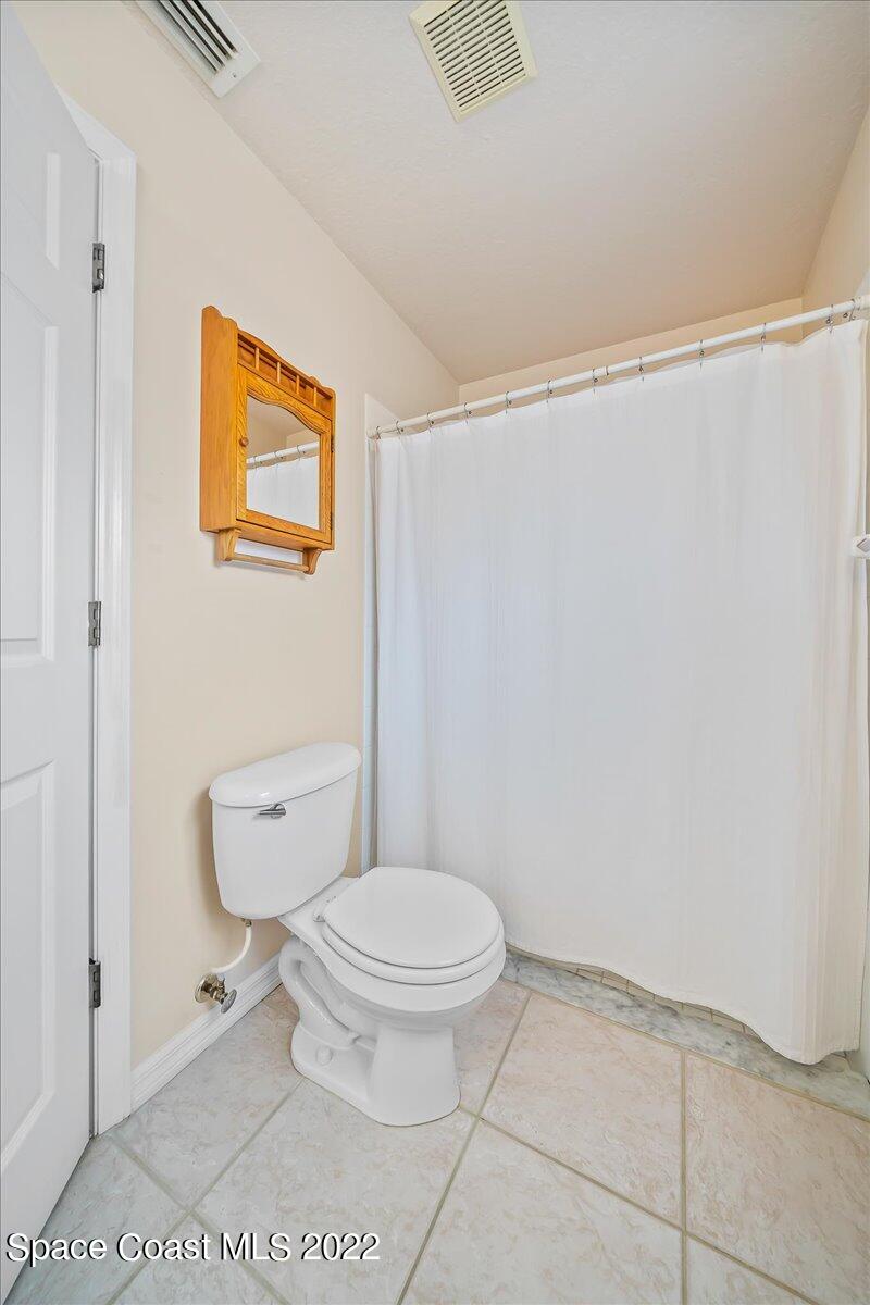 1965 Sundew Court Northeast Palm Bay, FL 32905 - Photo 24 of 29 a white toilet sitting next to a bathroom sink