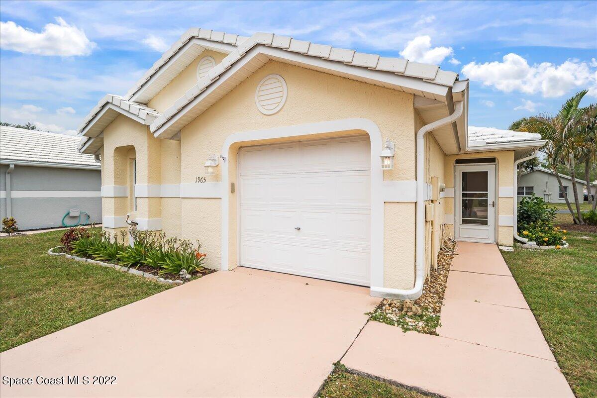 1965 Sundew Court Northeast Palm Bay, FL 32905 - Photo 5 of 29 a front view of a house with a yard
