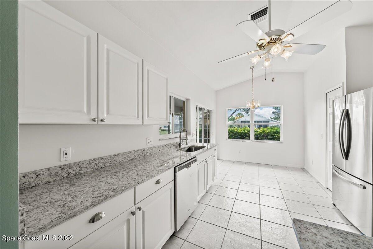 1965 Sundew Court Northeast Palm Bay, FL 32905 - Photo 8 of 29 a kitchen with a sink a refrigerator and cabinets
