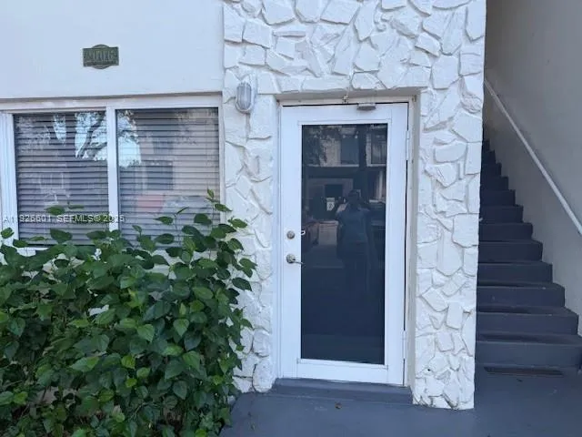 a front view of a house with a tree