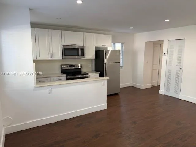 a kitchen with stainless steel appliances a refrigerator a stove a microwave and cabinets