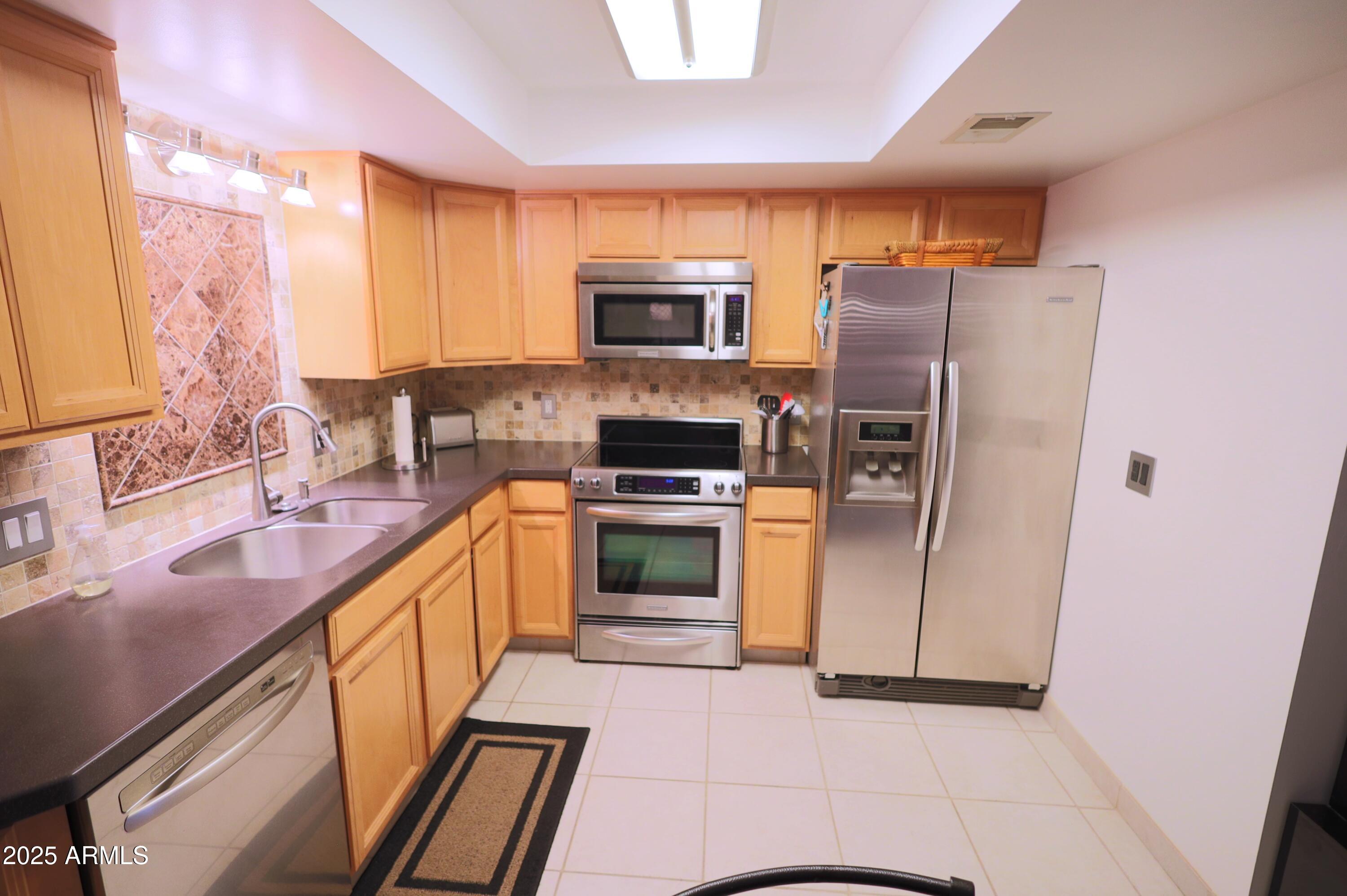 7820 East Camelback Road, Unit 309 Scottsdale, AZ 85251 - Photo 13 of 55 a kitchen with stainless steel appliances a refrigerator sink and microwave