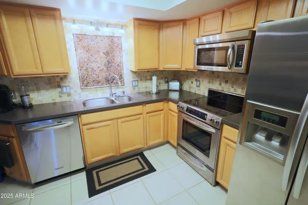a kitchen with stainless steel appliances a stove microwave and sink