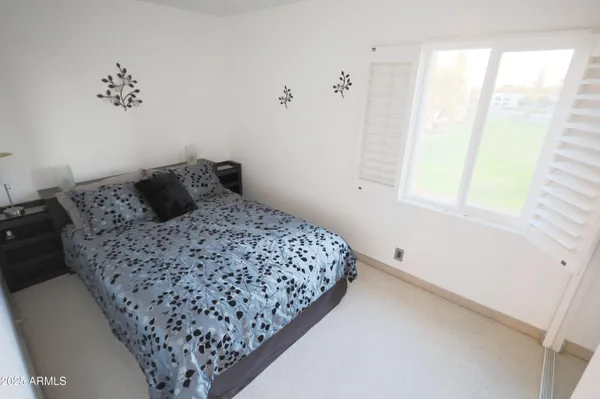 a bedroom with a bed and a wall painting