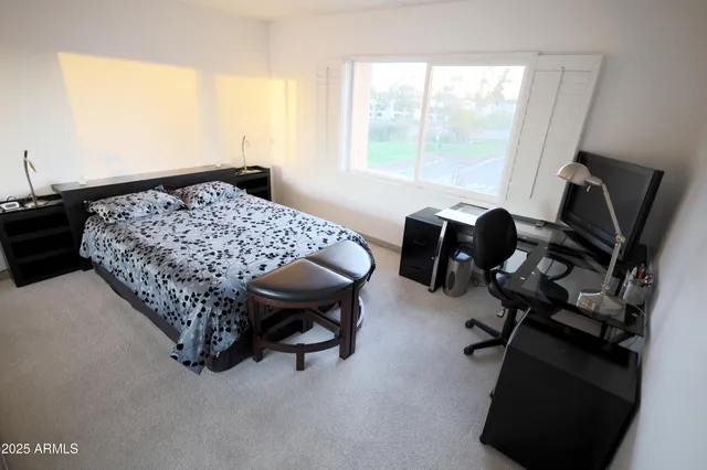 a bedroom with a bed and a flat screen tv
