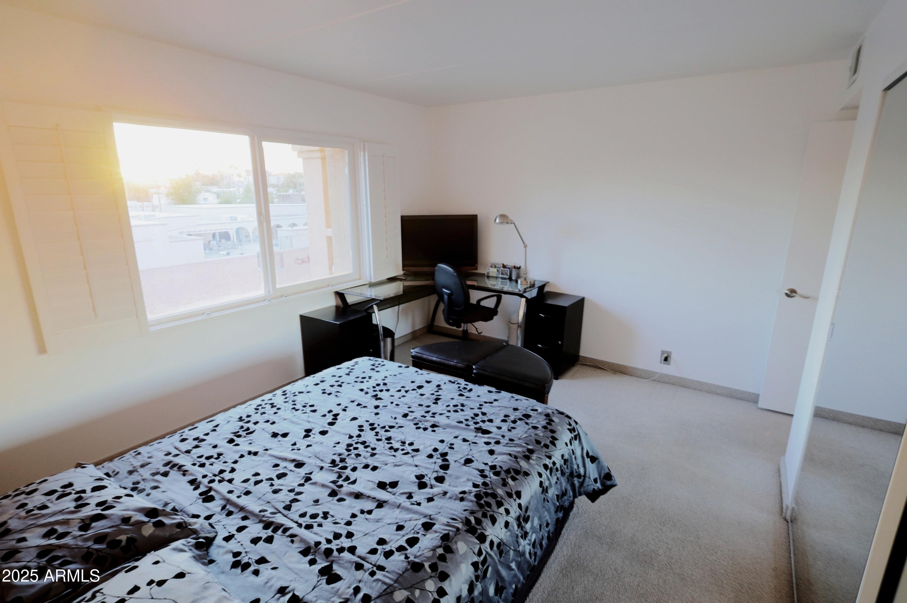 7820 East Camelback Road, Unit 309 Scottsdale, AZ 85251 - Photo 30 of 55 a bedroom with a bed and a flat screen tv