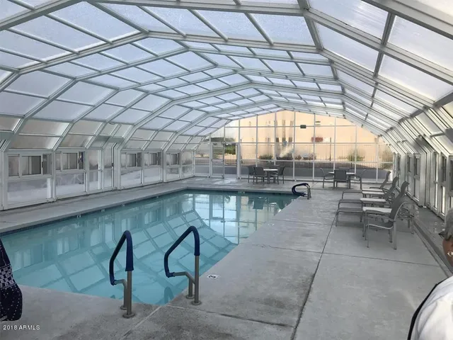 a view of a building with a big yard and large trees