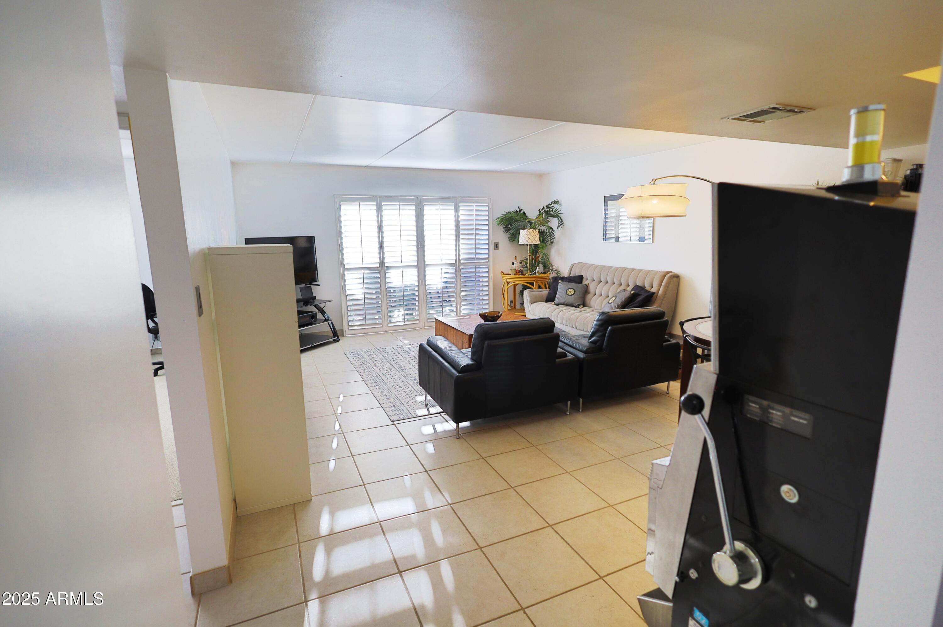 7820 East Camelback Road, Unit 309 Scottsdale, AZ 85251 - Photo 8 of 55 a living room with a couch and a flat screen tv