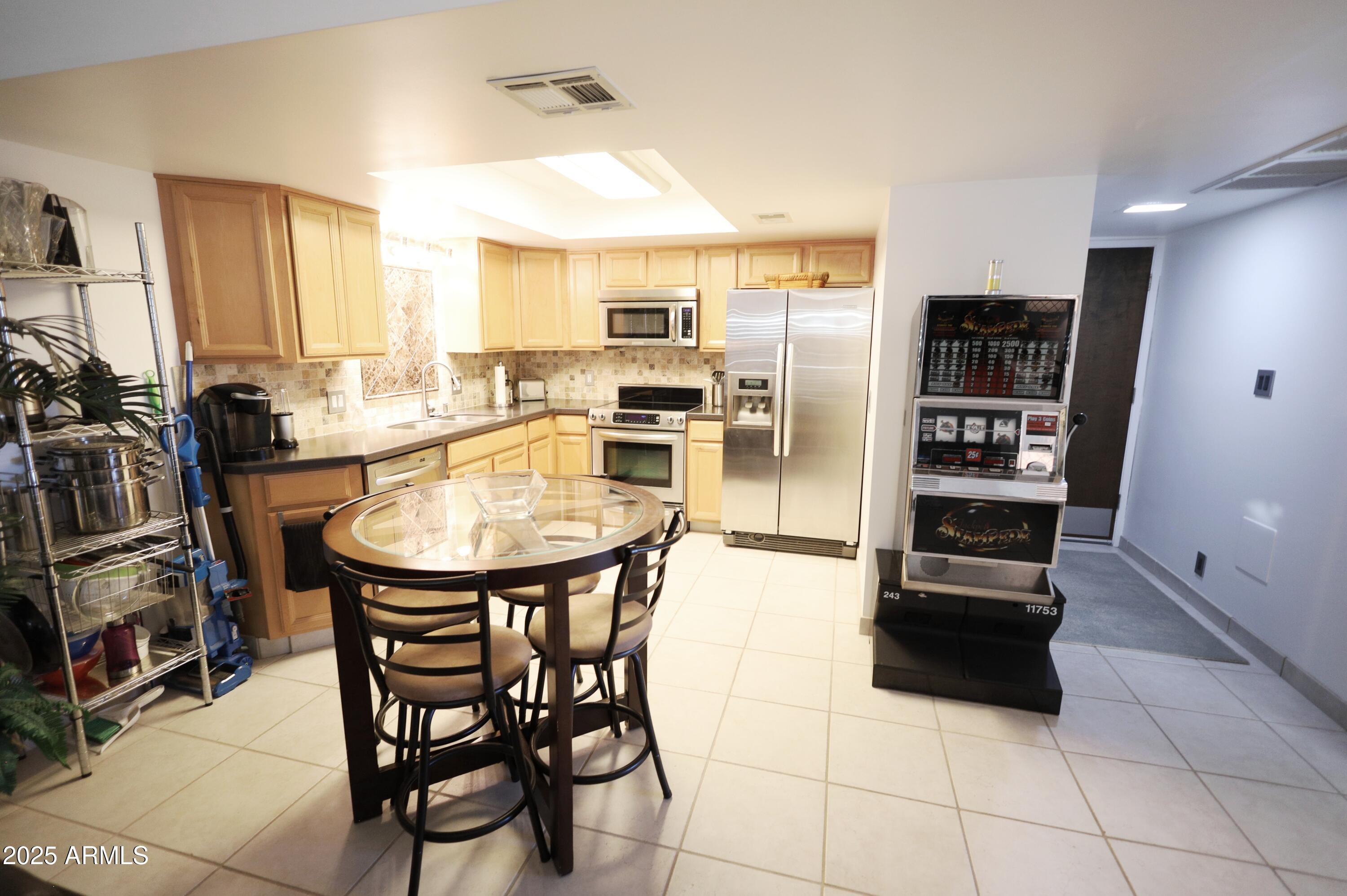 7820 East Camelback Road, Unit 309 Scottsdale, AZ 85251 - Photo 9 of 55 a kitchen with stainless steel appliances kitchen island granite countertop a refrigerator and wooden cabinets