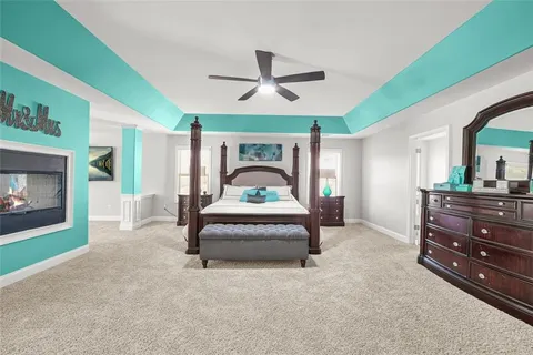 a bedroom with a bed and dresser with wooden floor