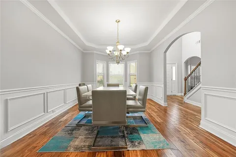 a view of a dining room with furniture a rug and wooden floor