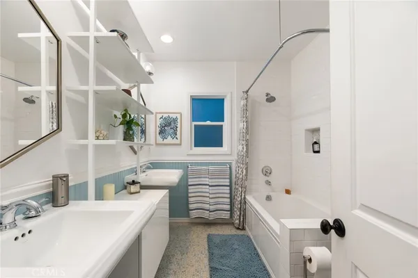 a bathroom with a tub sink and mirror