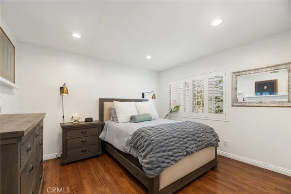 a bedroom with a bed and a flat tv screen on dresser