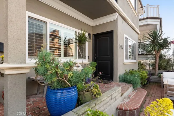 a view of a porch with chairs and potted plants