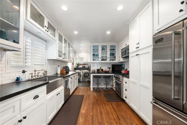 a kitchen with kitchen island granite countertop lots of counter top space and refrigerator