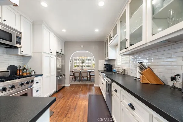 a kitchen with stainless steel appliances a sink a stove top oven a counter space and cabinets