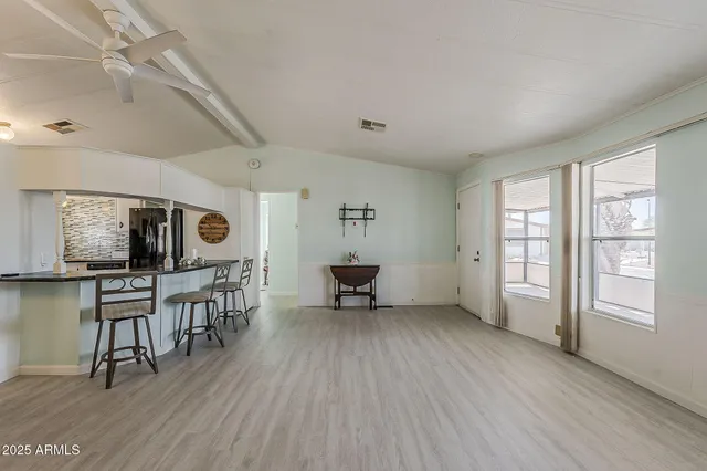 a living room with furniture a table and wooden floor