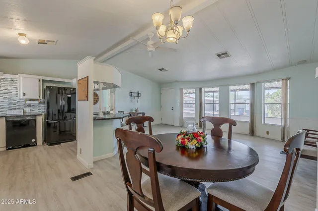 a view of a dining room with furniture a livingroom and chandelier