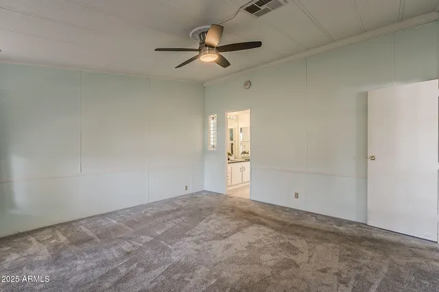 an empty room with a ceiling fan and window