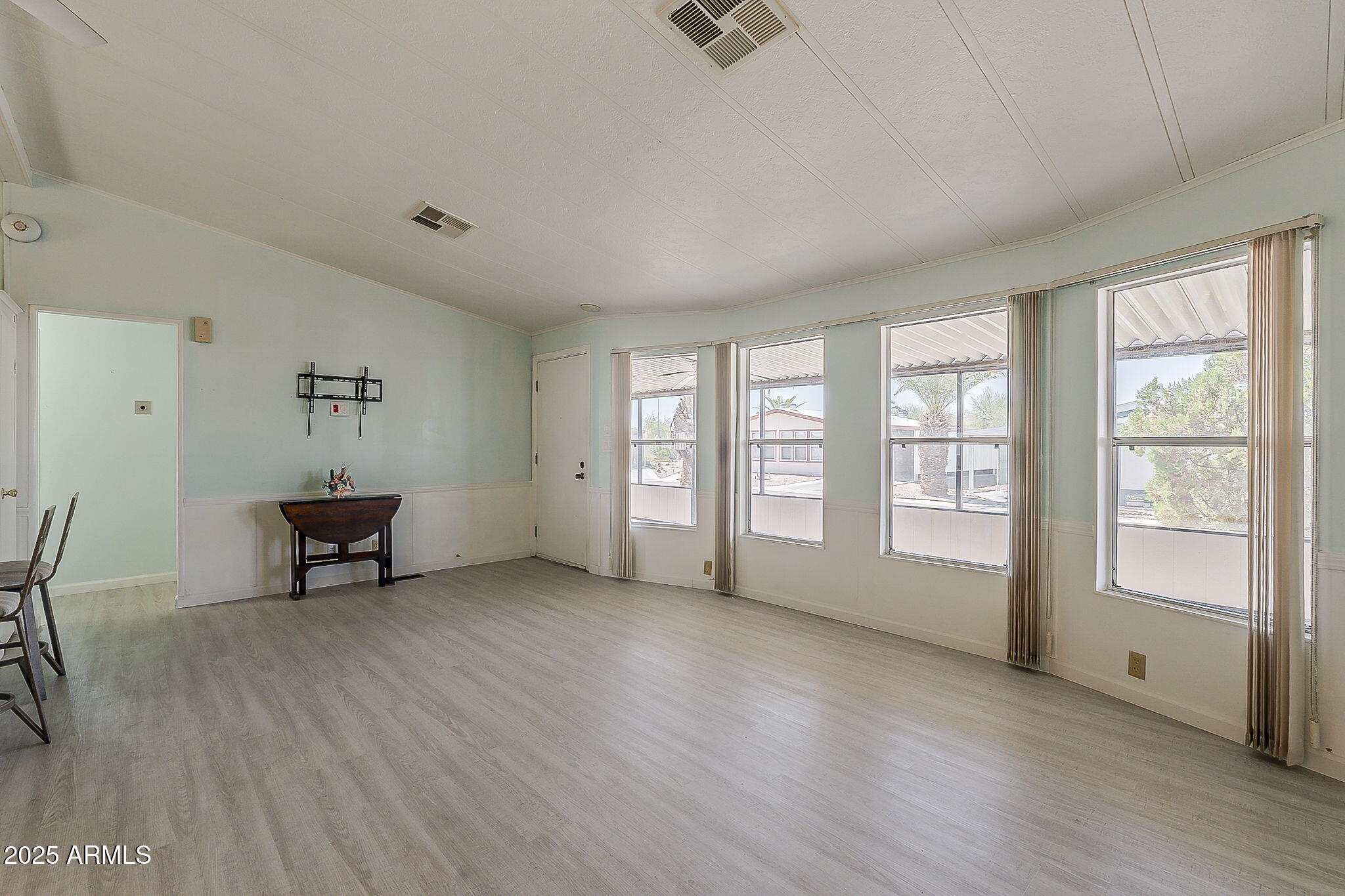834 South Meridian Road, Unit 118 Apache Junction, AZ 85120 - Photo 6 of 43 a view of an empty room with a window and wooden floor