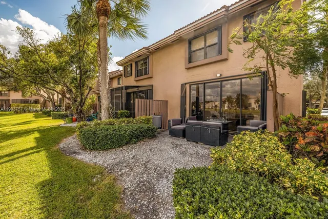 a view of a house with backyard and sitting area