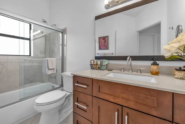 a bathroom with a granite countertop toilet sink and mirror