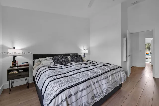 a bedroom with bed and wooden floor
