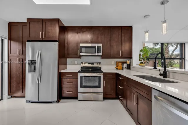a kitchen with stainless steel appliances granite countertop a refrigerator stove and sink