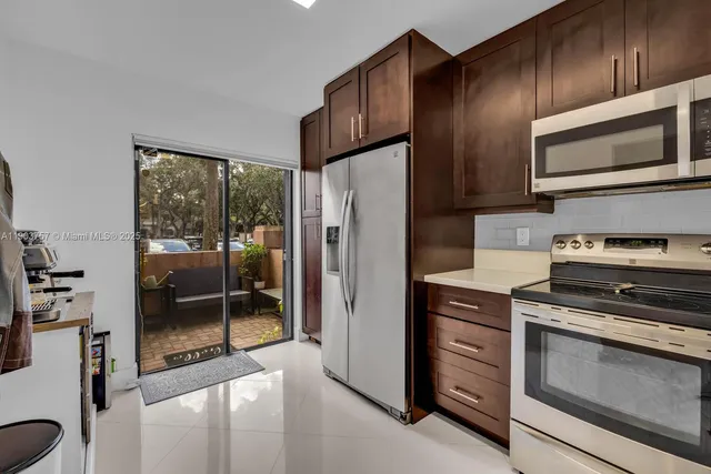 a kitchen with granite countertop wooden cabinets and stainless steel appliances