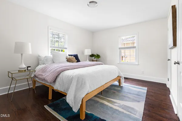a bedroom with a bed lamp and a window