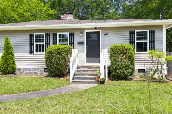 a front view of a house with a yard and plants
