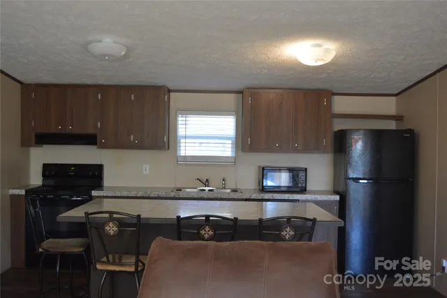 a kitchen with a refrigerator and a stove top oven