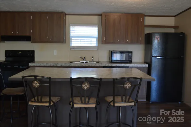 a kitchen with a table chairs refrigerator and microwave