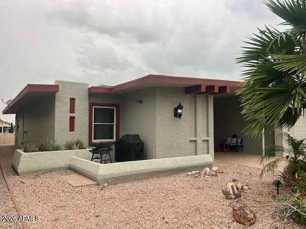 a view of a house with a patio and a yard