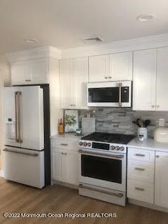 a kitchen with white cabinets and stainless steel appliances