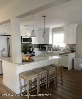 a kitchen with stainless steel appliances granite countertop a table chairs sink refrigerator and cabinets