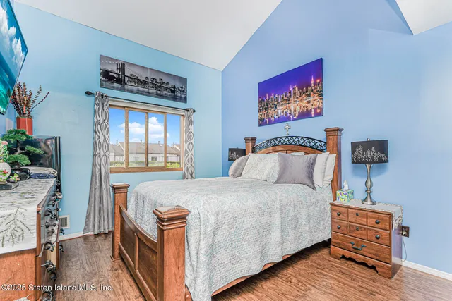 a bedroom with bed and wooden floor