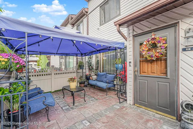 a view of patio with a table and chairs under an umbrella