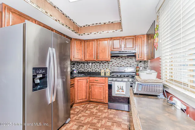 a kitchen with stainless steel appliances granite countertop a refrigerator a stove and sink