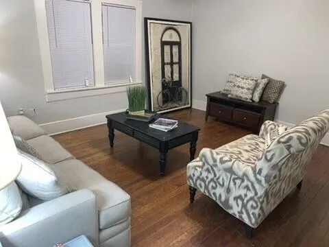 a living room with furniture and wooden floor