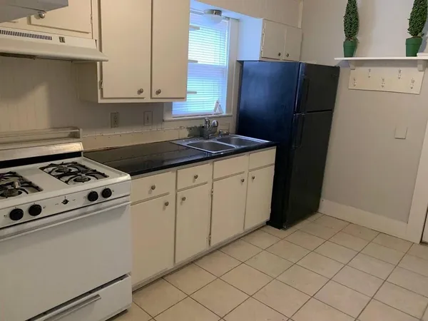 a kitchen with stainless steel appliances granite countertop a refrigerator and a stove