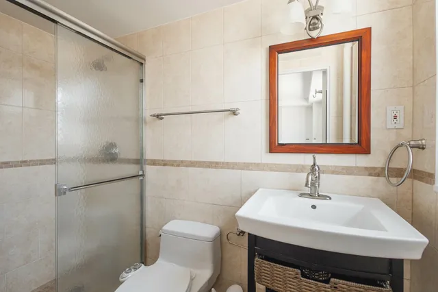 a bathroom with a sink a toilet and shower