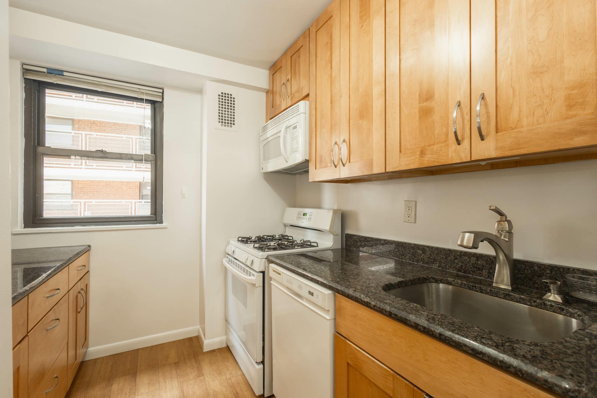 61-25 98th Street, Unit 11E Queens, NY 11374 - Photo 10 of 31 a kitchen with granite countertop a sink a stove and cabinets