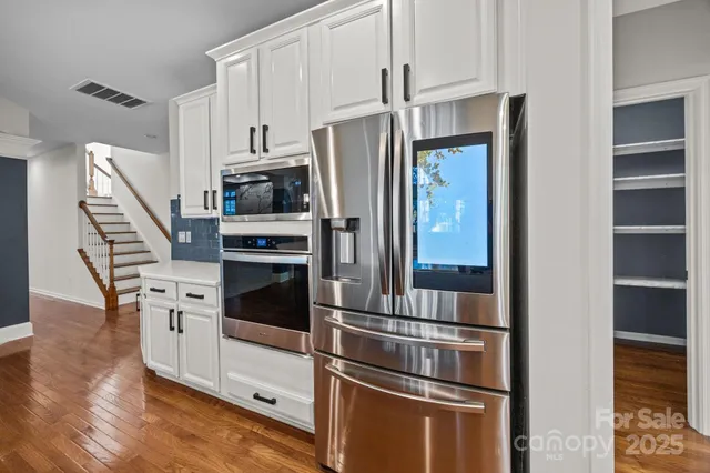 a kitchen with stainless steel appliances and refrigerator