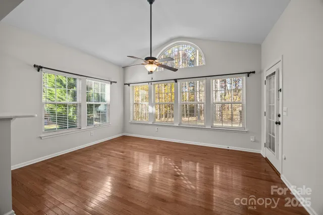 an empty room with windows and fan