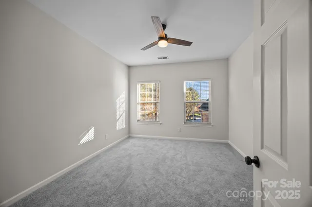 a view of a big room with chandelier fan and windows