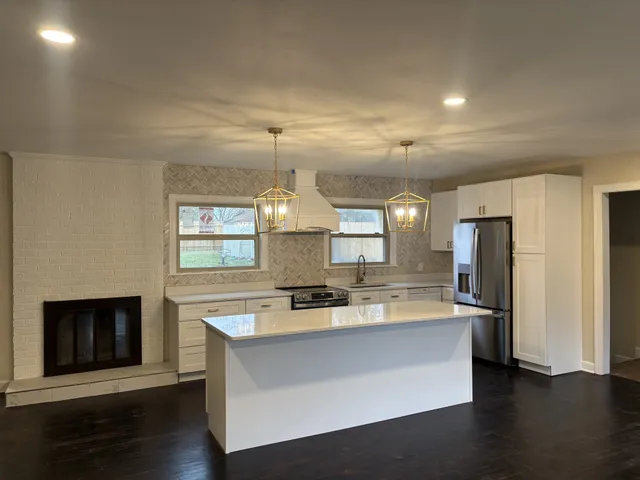 a large kitchen with kitchen island a sink stainless steel appliances and cabinets